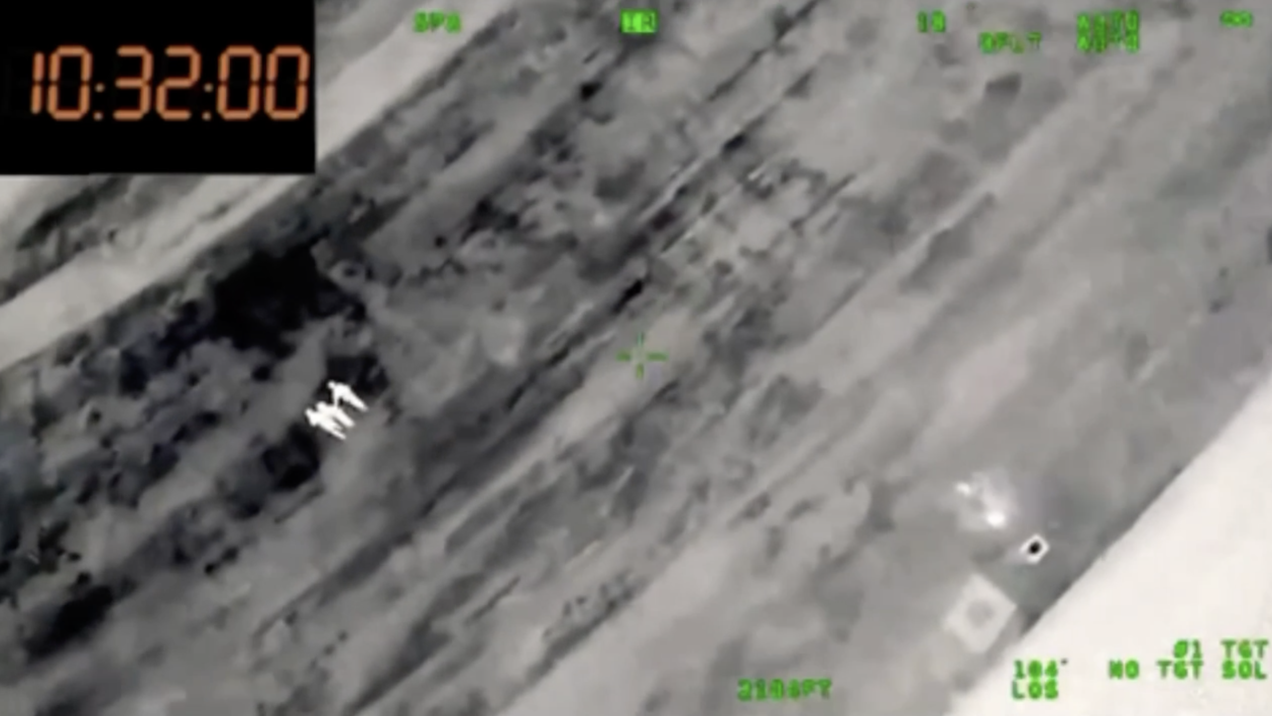 Infrared aerial view showing multiple figures and vehicle